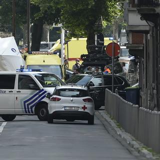 Une véhicule de la police belge et une ambulance sur le lieu de la fusillade. [AFP Belgique - John Thys]