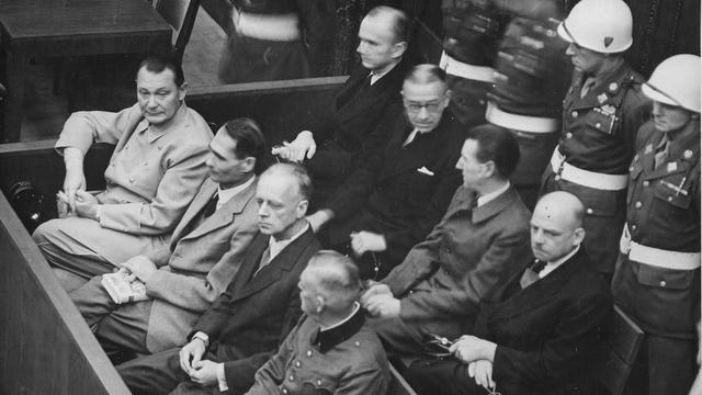 Procès de Nuremberg (1945-1946), les accusés dans leur box. Au premier rang, de gauche à droite: Hermann Göring, Rudolf Heß, Joachim von Ribbentrop, Wilhelm Keitel. Second rang: Karl Dönitz, Erich Raeder, Baldur von Schirach, Fritz Sauckel.  (National Archives and Records Administration)