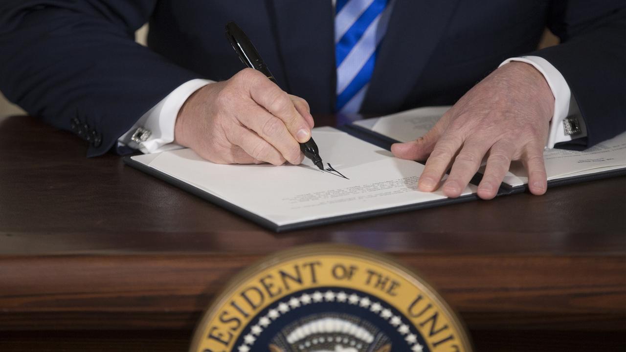 Le président américain Donald Trump signe un mémorandum présidentiel sur l'Iran, le 8 mai 2018. [EPA - Michael Reynolds]