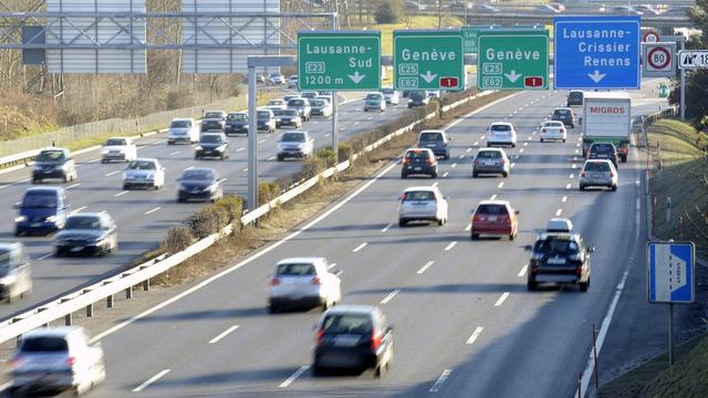 Des voitures circulent sous des panneaux de signalisation Lausanne - Genève sur l'autoroute A1. [Keystone - Laurent Gillieron]