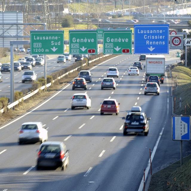 Des voitures circulent sous des panneaux de signalisation Lausanne - Genève sur l'autoroute A1. [Keystone - Laurent Gillieron]