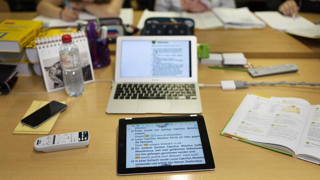 Une tablette et un ordinateur photographiés dans une salle de classe à Soleure. [Keystone - Christian Beutler]