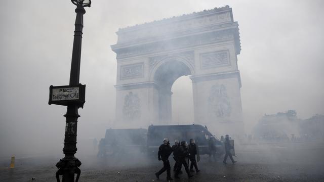 Des policiers anti-émeutes devant l'Arc de Triomphe à Parsi, lors de la manifestation des "gilets jaunes" du 1er décembre. [EPA - YOAN VALAT]