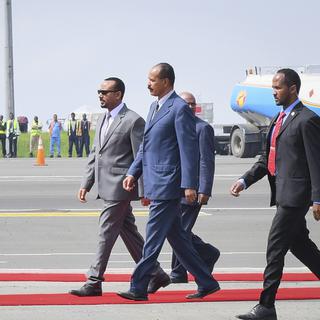 Le président érythréen Isaias Afwerki (ici, à droite en costume bleu marine), marche avec le Premier ministre éthiopien Abiy Ahmed (ici, à gauche en costume gris), sur le tarmac de l'aéroport d'Addis Abeba. [EPA/STRINGER]