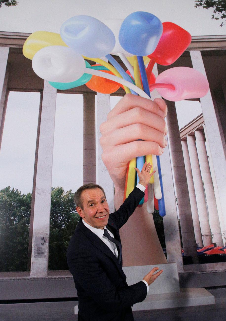 L'artiste américain Jeff Koons pose à l'ambassade américaine à Paris le 21 novembre 2016 devant une illustration de son "Bouquet of Tulips", une sculpture de 10,40 mètres de haut qu'il souhaite offrir à la Ville de Paris. [Keystone - Michel Euler]