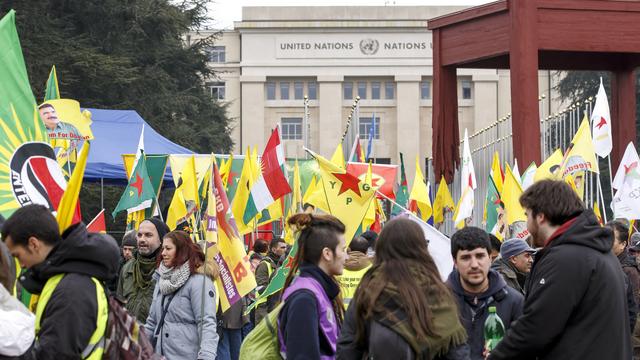 Des centaines de manifestants se sont rassemblés vendredi 16 février devant le siège de l'ONU à Genève pour protester contre les attaques sur la ville d'Afrine. [Keystone - Salvatore Di Nolfi]