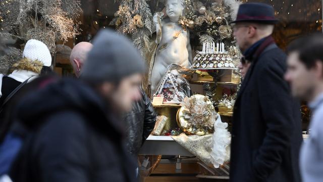 Des passants devant une vitrine de magasin (image d'illustration). [Keystone - Walter Bieri]