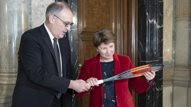 Guy Parmelin remet une raquette de tennis à Viola Amherd. [Keystone - Peter Schneider]