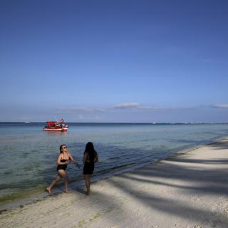 Des touristes sur une plage quasi déserte de l'île de Boraçay, aux Philippines. [AP/Keystone - Aaron Favila]