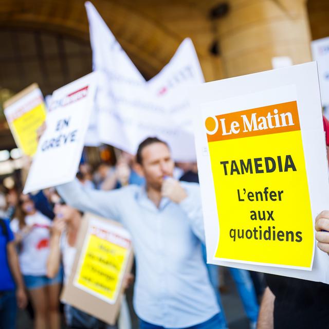 Des journalistes de Tamedia manifestent pendant la grève menée contre les licenciements annoncés par le groupe, le 4 juillet 2018 à Lausanne. [Keystone - Valentin Flauraud]