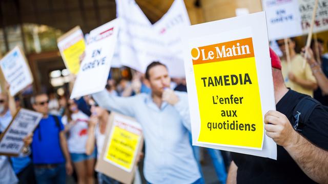 Des journalistes de Tamedia manifestent pendant la grève menée contre les licenciements annoncés par le groupe, le 4 juillet 2018 à Lausanne. [Keystone - Valentin Flauraud]