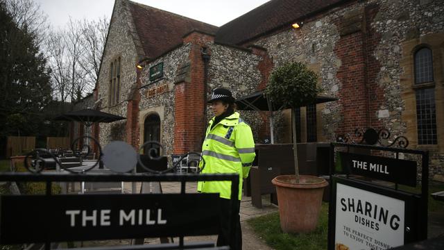 Une officière de police devant le Mill pub de Salisbury, où des traces d'agent innervant ont été retrouvées. [AFP - Daniel LEAL-OLIVAS]