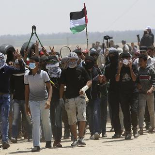 Des jeunes Palestiniens manifestent sur la frontière entre Israël et Gaza. [Keystone - Adel Hana]