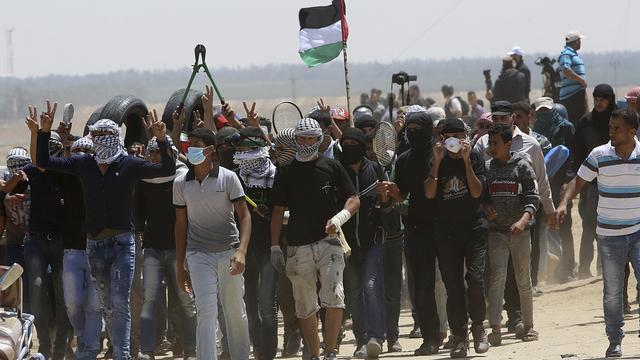 Des jeunes Palestiniens manifestent sur la frontière entre Israël et Gaza. [Keystone - Adel Hana]