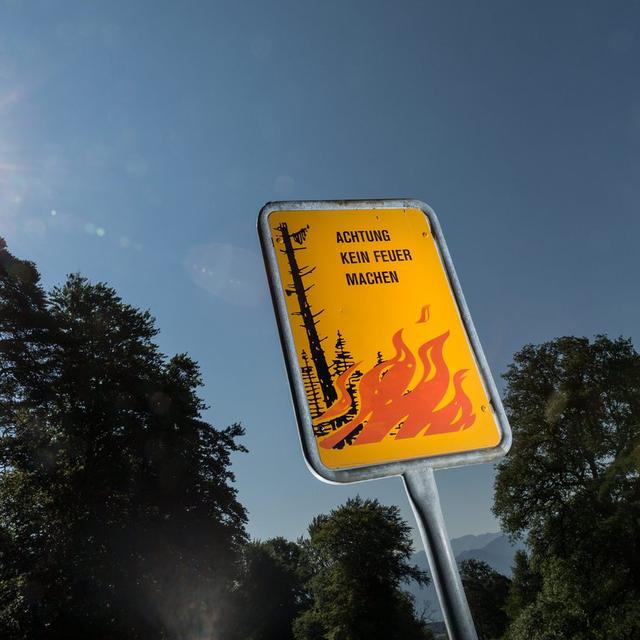 Un panneau d'interdiction de faire du feu installé à Maienfeld, dans les grisons, en juillet 2013. [Keystone - Arno Balzarini]