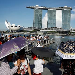 Des touristes se protègent contre la chaleur à Singapour. [Reuters - Edgar Su]