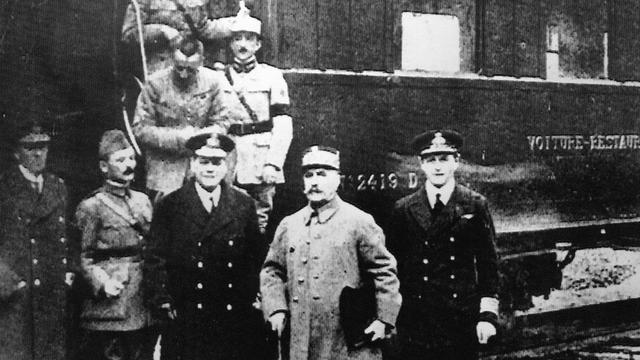 Les signataires de l'armistice, le 11 novembre 1918, à Rethondes (France) devant le train du maréchal Ferdinand Foch, accompagné du général Maxime Weygand. [Keystone]