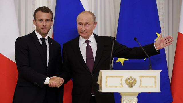 Le président français Emmanuel Macron (gauche) et le président russe Vladimir Poutine (droite) lors d'une conférence commune à St-Pétersbourg, en Russie. [Keystone - Dmitri Lovetsky]