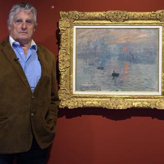 Léonard Gianadda pose devant "Impression, soleil levant" de Monet en 2017. [Keystone - Laurent Gilliéron]