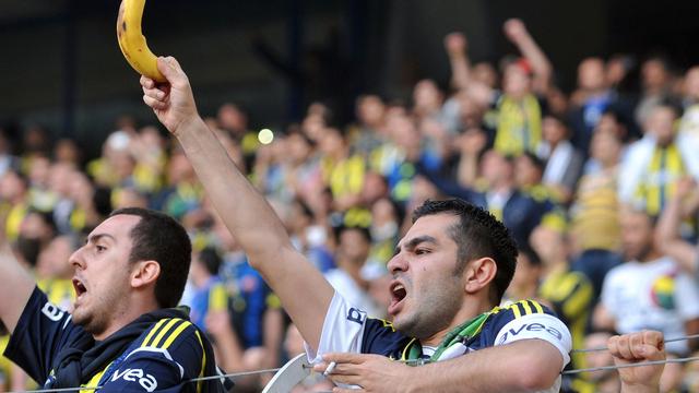 Un supporter brandit une banane à l'entrée d'un joueur de couleur sur le terrain à Istanbul en 2013. [AFP - Ozan Kose]