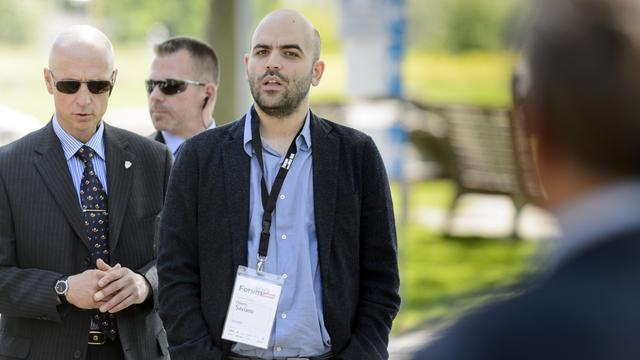 Roberto Saviano, (au premier plan, badgé), entouré de deux gardes du corps, à Lausanne en 2015. [Keystone - Laurent Gilliéron]