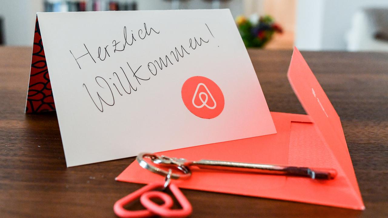 Un porte-clé et une carte de bienvenue dans un logement loué via la plateforme Airbnb. [Keystone - Jens Kalaene]