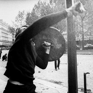 Manifestant lançant un pavé en direction de policiers en mai 1968. [AP/Keystone]