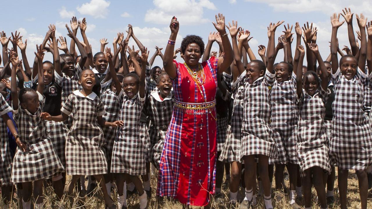 Des filles kenyanes, qui ont fuit leur foyer pour échapper à l'excision, posent avec la fondatrice de l'association Nanana Winbridge Education Center. [Keystone - Daniel Irungu]