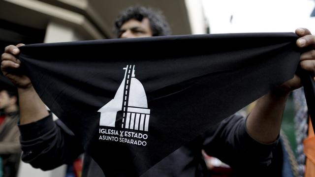 Des mouchoirs prônant la séparation de l'Eglise et de l'Etat sont distribués à Buenos Aires, le 18 août 2018. [keystone - Natacha Pisarenko]