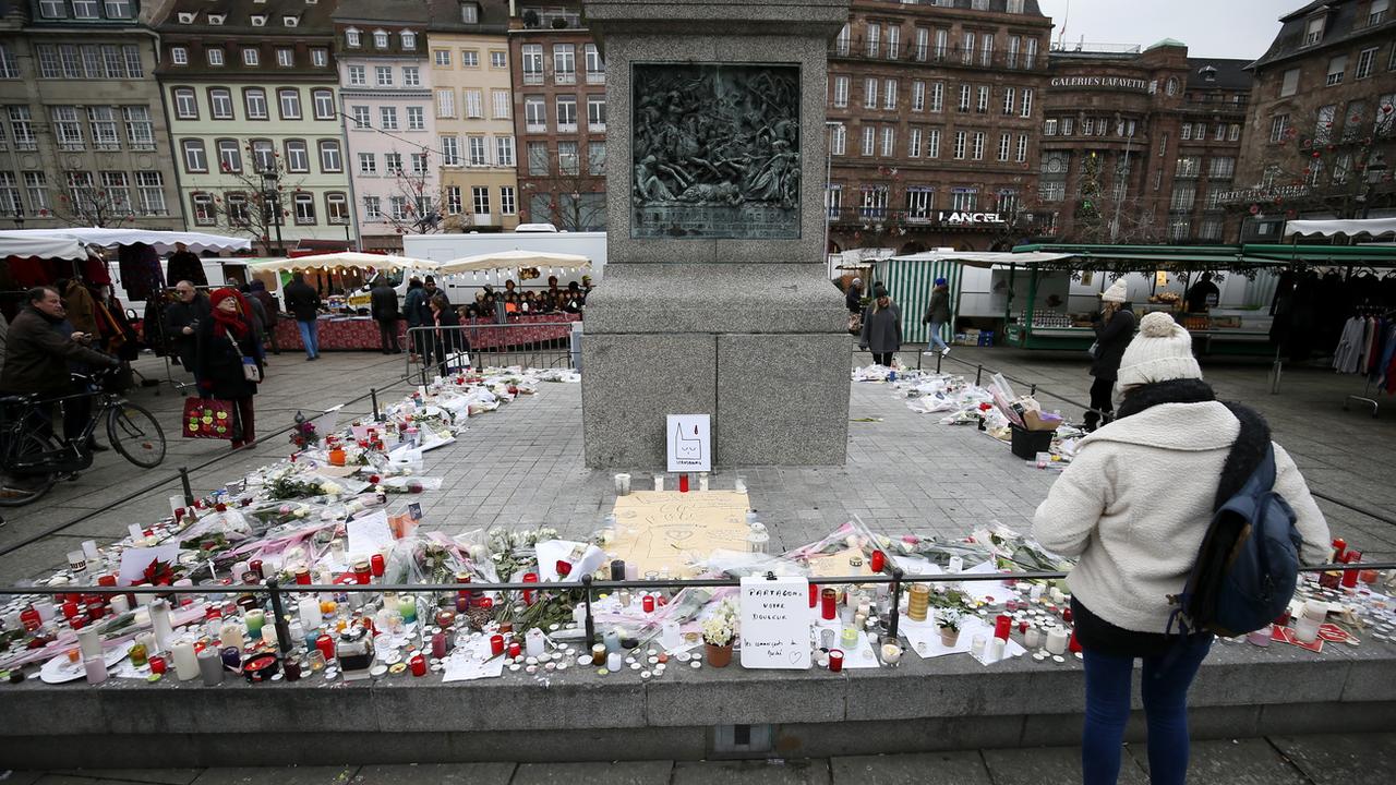 Bougies, lettres et fleurs en hommage aux victimes de la fusillade de Strasbourg, sur une place proche du Marché de Noël, ce 14 décembre 2018. [EPA - RONALD WITTEK]