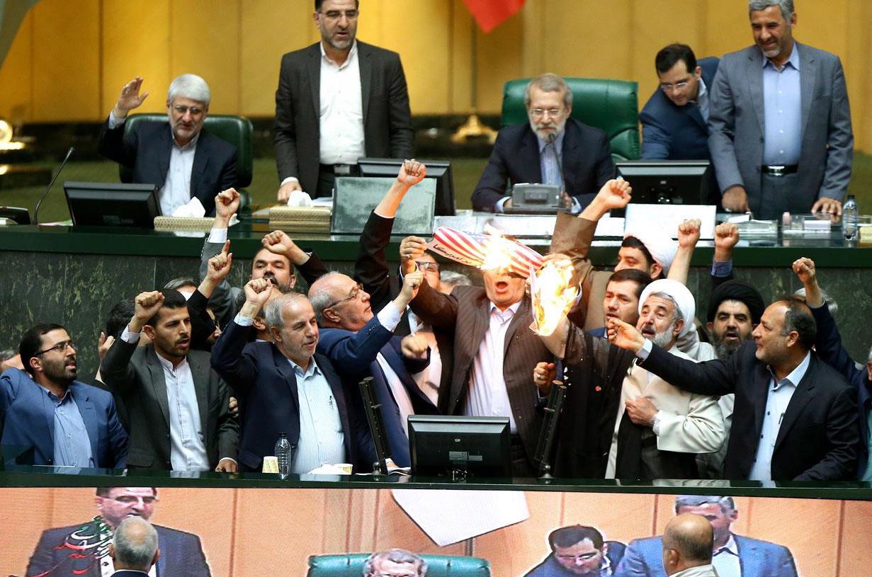 Un drapeau américain brûlé au Parlement iranien. [Keystone - EPA/Parliament Office]