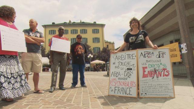 Sandra Rimet proteste à Sion avec sa pancarte pour récupérer la garde de son fils. [RTS - DR]