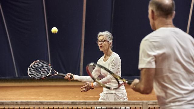 Un couple de retraités jouant au tennis. [Keystone - Christof Schuerpf]