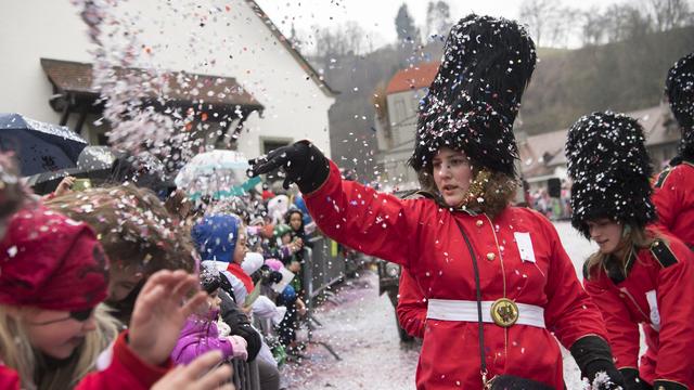 Des participants au grand cortège du Carnaval des Bolzes, au travers de la ville de Fribourg. [Keystone - Anthony Anex]