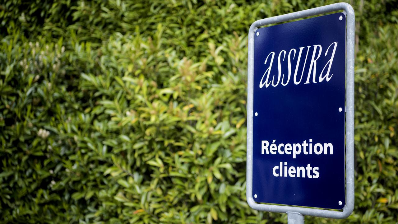Le logo d'Assura devant le siège social de l'assureur à Pully (VD). [Keystone - Jean-Christophe Bott]
