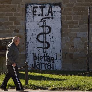 Un homme passe devant l'emblème de l'ETA, un serpent enroulé autour d'une hache, à Arbizu, en Espagne en 2011. [AP - Alvaro Barrientos]
