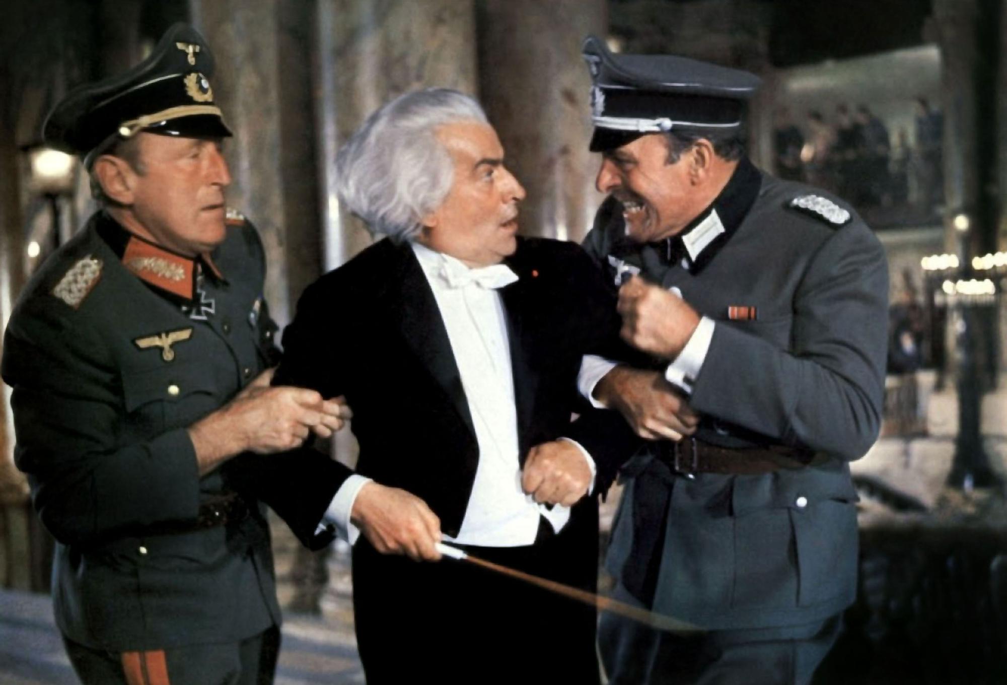 Louis de Funès, en chef d'orchestre, entouré de Bourvil à gauche et de Terry-Thomas. [Les Films Corona / Collection ChristopheL / AFP]