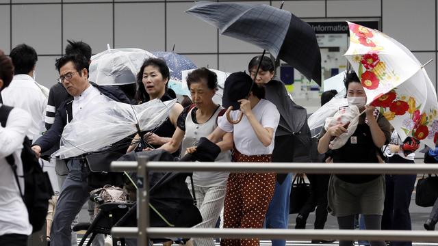 Des habitants de Tokyo luttent contre le vent, ce 4 septembre 2018. [EPA - KIMIMASA MAYAMA]