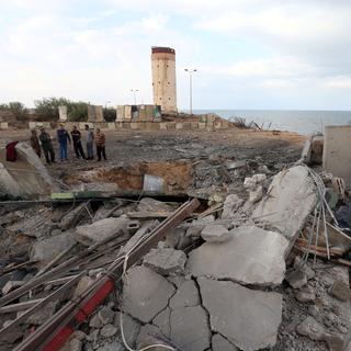 Un groupe de Palestiniens inspecte un endroit que l'armée israélienne a bombardé dans la bande de Gaza. [Ibraheem Abu Mustafa]