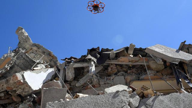 Un drone survole les débris d'une école en Italie après un séisme. [ANSA via AP/Keystone - Alessandro Di Meo]