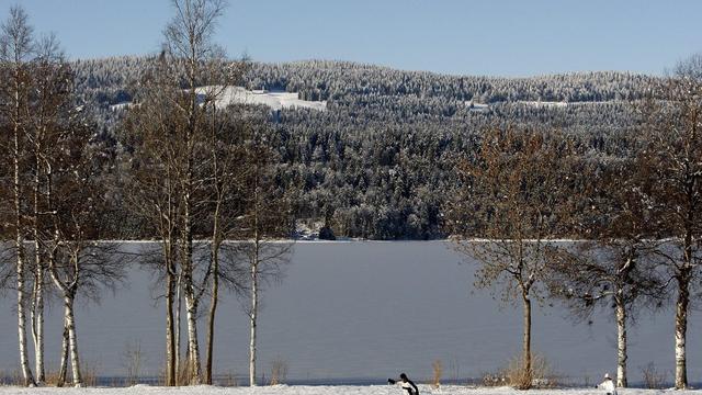 Des skieurs de fond sur une piste autour du lac de Joux. [Keystone - Jean-Christophe Bott]