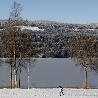Des skieurs de fond sur une piste autour du lac de Joux. [Keystone - Jean-Christophe Bott]