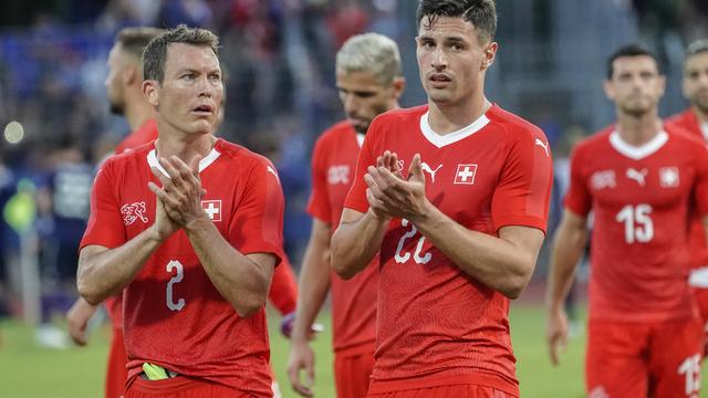 Lichtsteiner et Schär applaudissent le public après la rencontre. [Andy Müller]