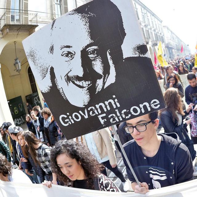 Des manifestants défilent à Turin, le 21 mars 2016, avec une pancarte en souvenir du juge Falcone, assassiné par la mafia. En Italie, le premier jour du printemps est dédié à la lutte contre le crime organisé. [Keystone - Alessandro Di Marco]