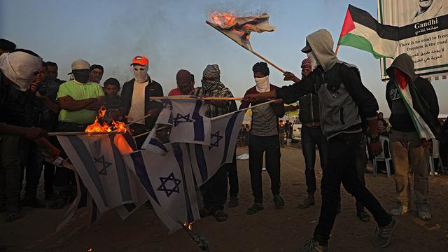 Des manifestants palestiniens brûlent des drapeaux d'Israël, le 17 avril 2018 à Gaza. [EPA/Keystone - Mohammed Saber]