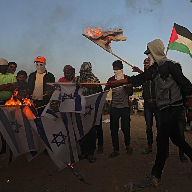 Des manifestants palestiniens brûlent des drapeaux d'Israël, le 17 avril 2018 à Gaza. [EPA/Keystone - Mohammed Saber]