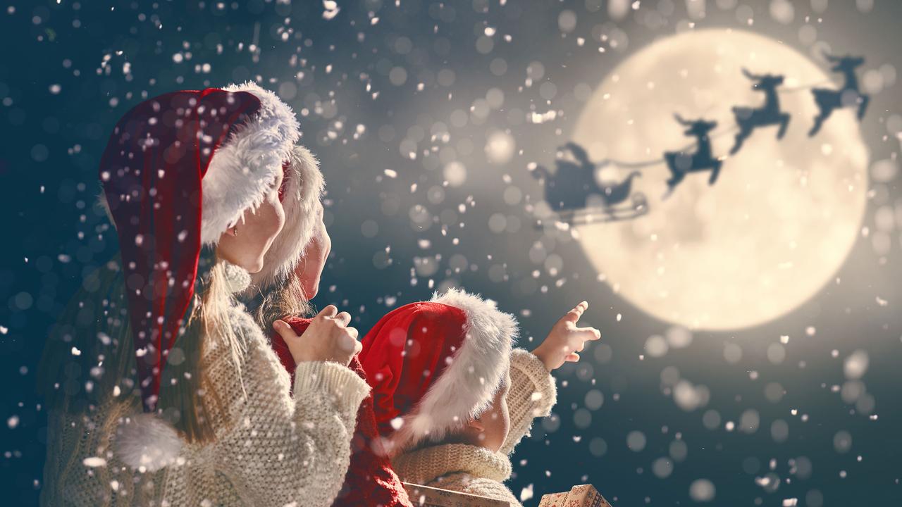 Des enfants regardent le Père-Noël dans le ciel. [Fotolia - Konstantin Yuganov]