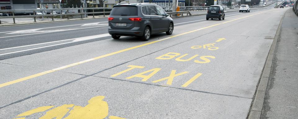 Une route à Genève avec une bande réservée aux bus, motos, vélos, taxis et bus. (Image d'illustration) [Keystone - Salvatore Di Nolfi)]