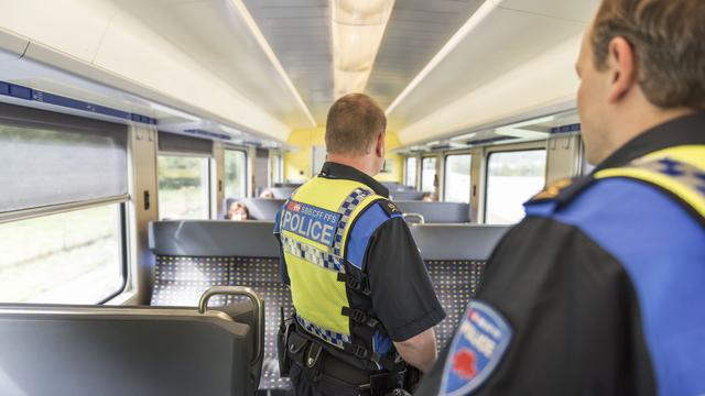 Des agents de la police des transports CFF patrouillent dans un train à hauteur de Bienne. [keystone - Christian Beutler]