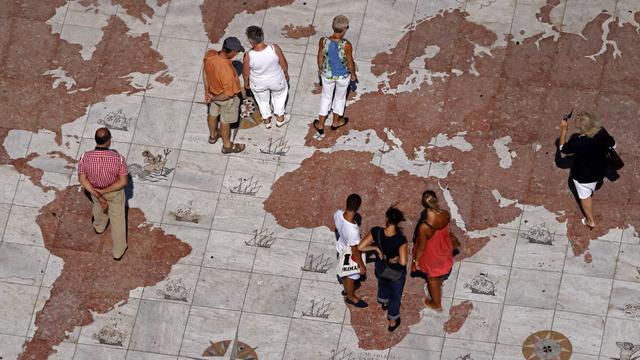 Des passants sur une grande carte du monde en marbre à Lisbonne, au Portugal. [Reuters - Jose Manuel Ribeiro]